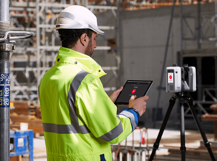Scan technician using a Leica RTC360 LiDAR scanner to capture a construction site for as-built documentation.