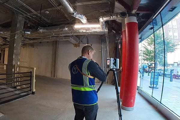 Scan technician performing construction laser scanning of MEP systems to capture field conditions for accurate as-built documentation and BIM coordination.