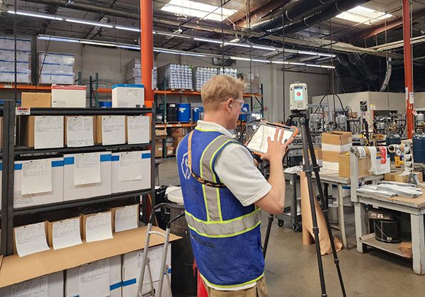 Technician performing a LiDAR laser scan inside an industrial facility