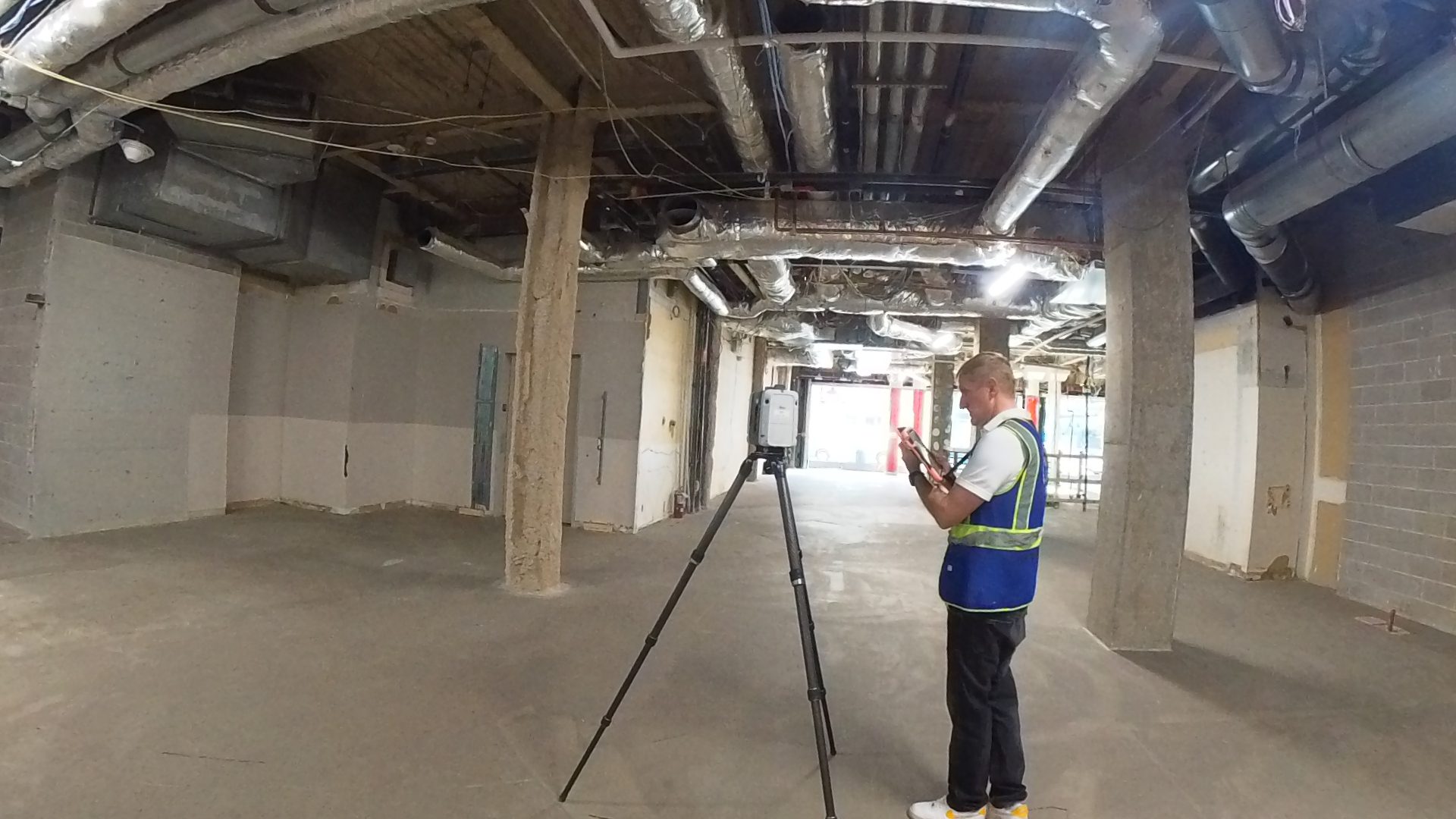Technician using a LiDAR laser scanner to capture existing conditions inside a commercial building