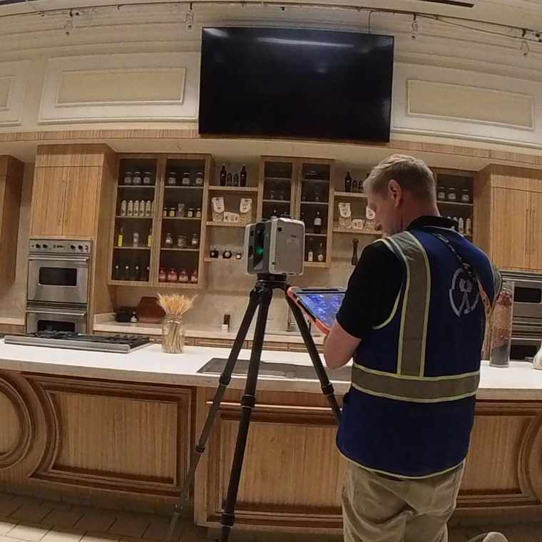 3D scanning technician capturing a high-end kitchen interior with laser scanning equipment for accurate as-built documentation.